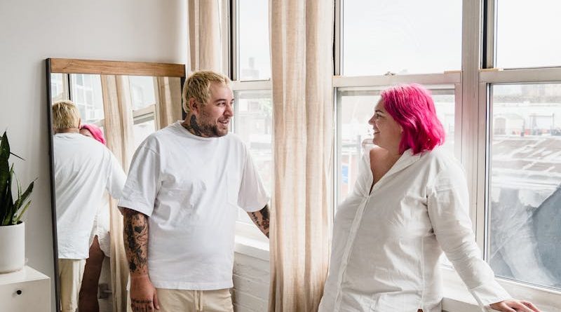 A couple stands indoors enjoying each other's company in a stylish and minimalistic apartment.