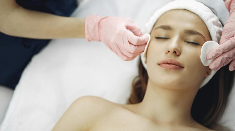Woman enjoying a soothing facial treatment in a serene spa setting, promoting relaxation and beauty.