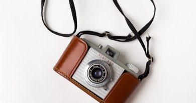 brown and gray SLR camera on white surface