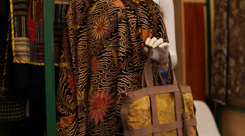 a mannequin wearing a hat and carrying a purse