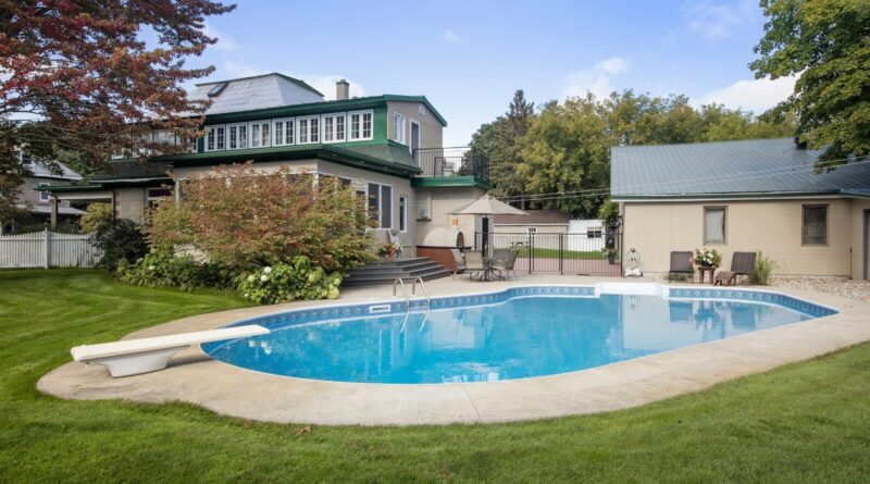 a backyard with a pool and a house in the background