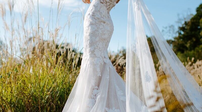 woman in white wedding dress standing on green grass field during daytime