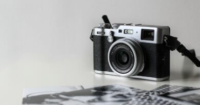 black and gray film camera near printed photos
