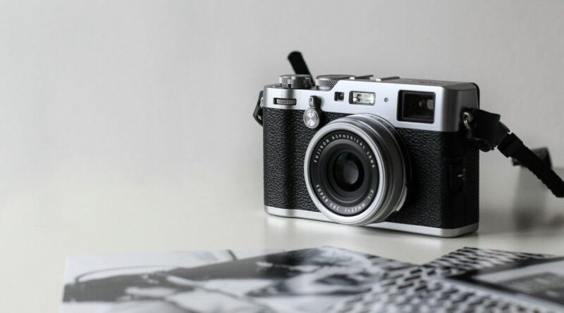 black and gray film camera near printed photos