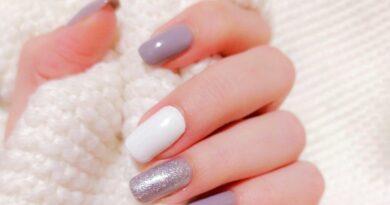 person with pink manicure on white textile