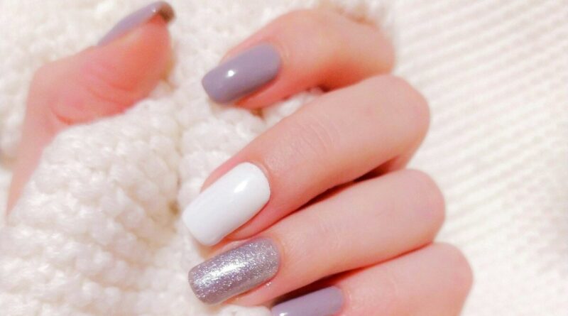 person with pink manicure on white textile